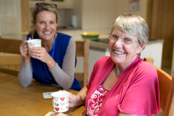 nurse and patient with coffee smiling at the camera